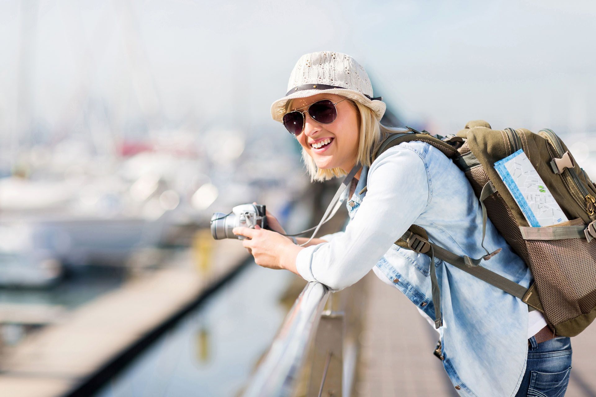 a woman with a backpack is taking a picture with a camera