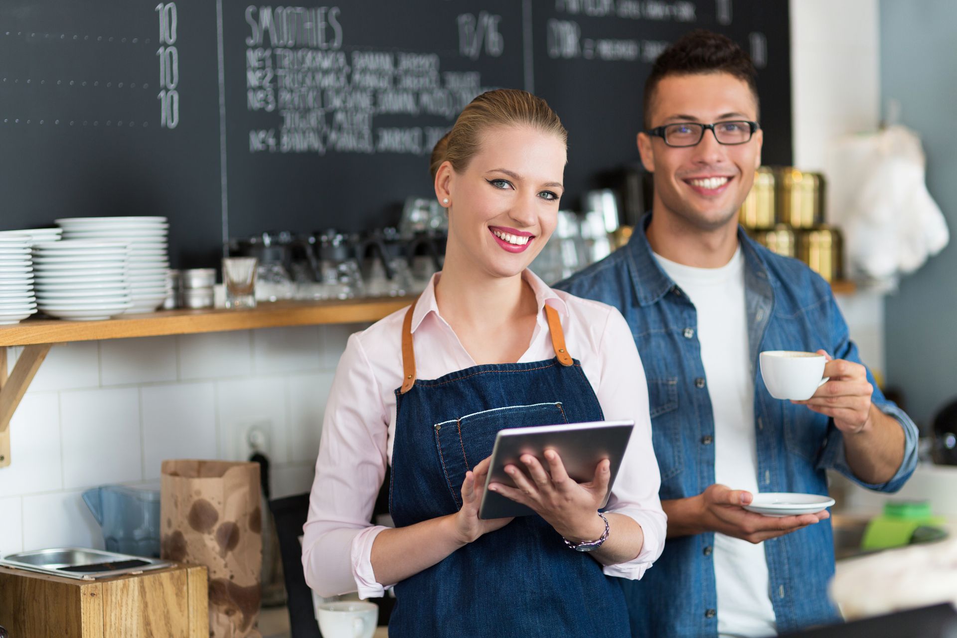 A man and a woman are standing next to each other in a restaurant.