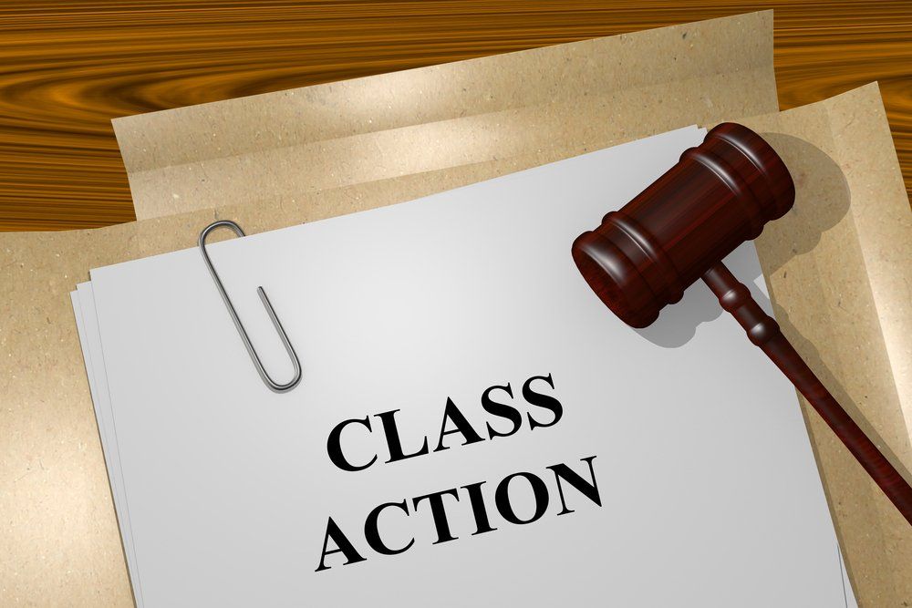 a piece of paper that says class action next to a judge 's gavel