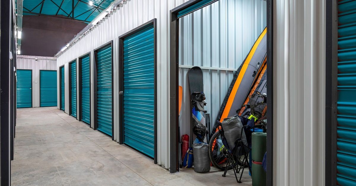 A storage facility with numerous storage lockers. One of the lockers is unlocked and opened.