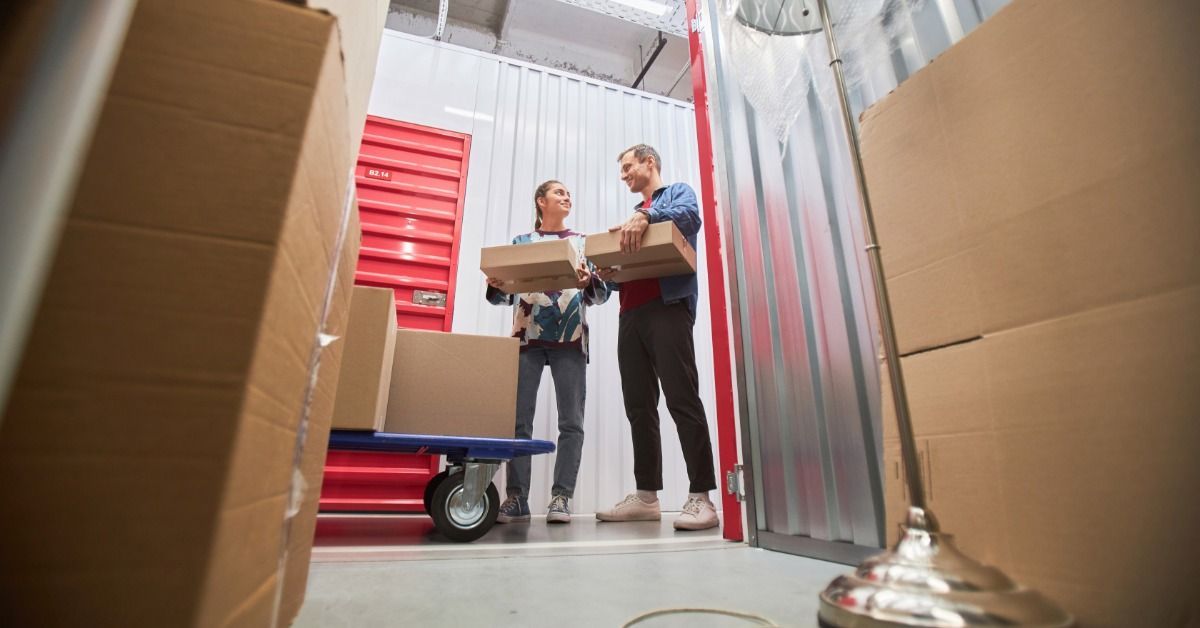 Two people, a man and a woman, are standing in front of an open storage unit.