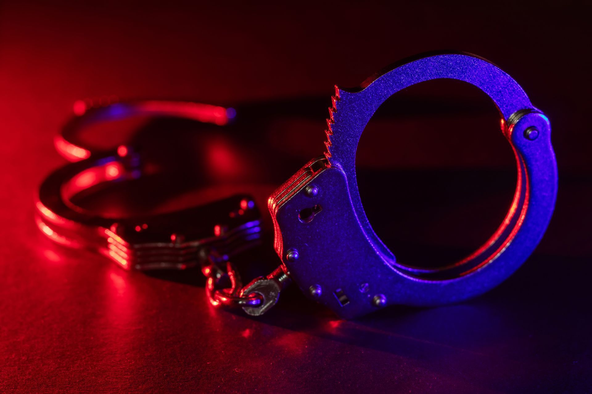 A pair of handcuffs on a red and blue background.