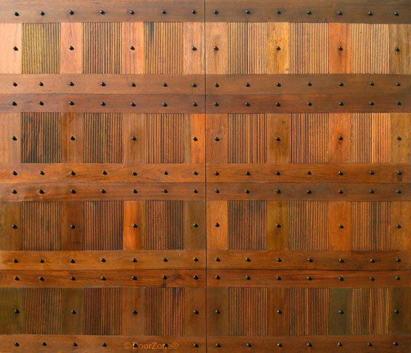 Wooden plank wall with horizontal metal bands and rows of rivets.