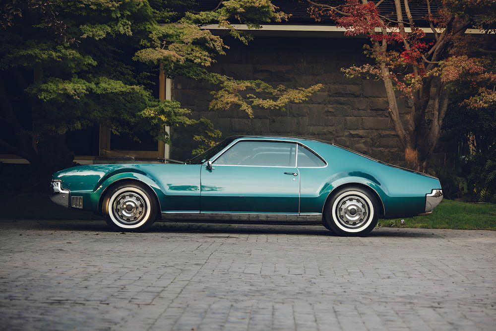 A Green Car Is Parked In Front Of A Brick Building — Hunter Automotive In Atherton, QLD

