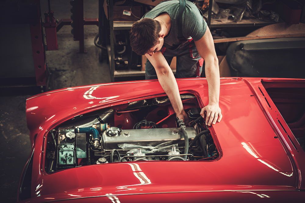 A Man Is Working On The Engine — Hunter Automotive In Atherton, QLD
