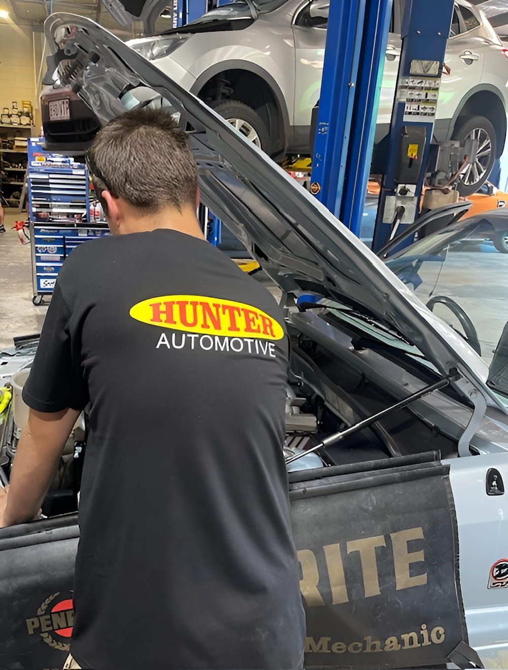 A Man Is Working On The Engine Of A Car In A Garage — Hunter Automotive In Bungalow, QLD