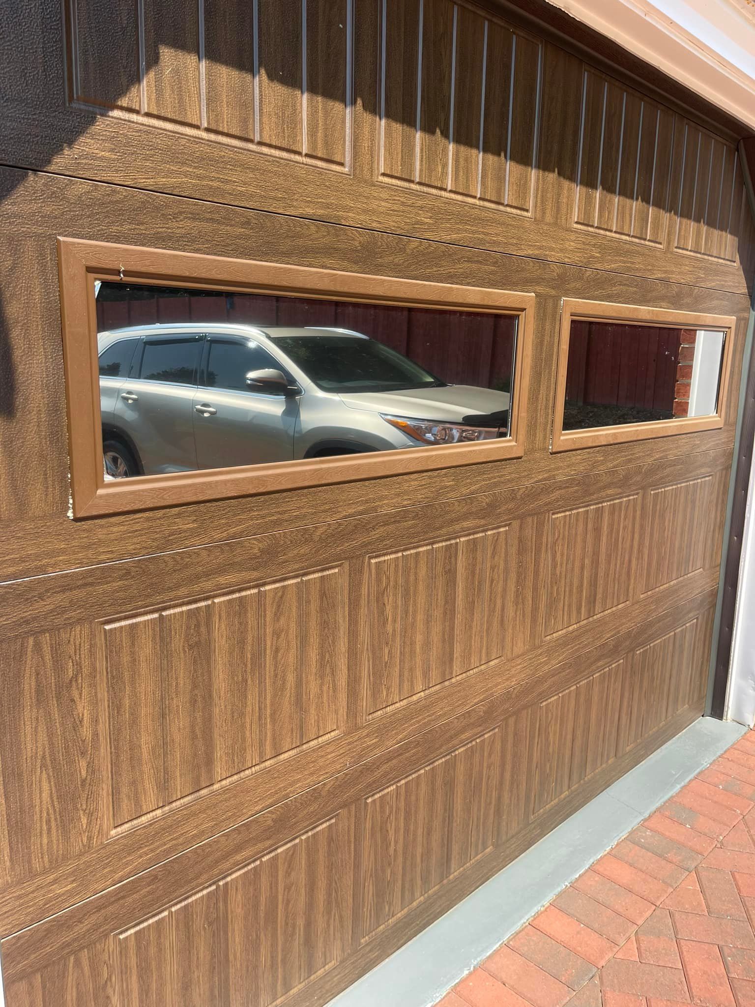 A car is parked in a garage with a wooden garage door.