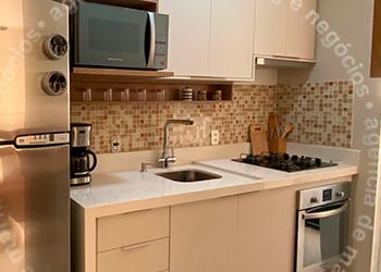 Uma cozinha com pia, geladeira, micro-ondas e forno.
