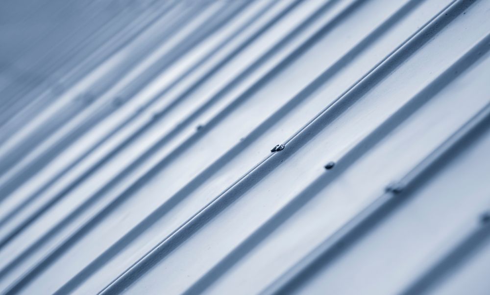 Blue-gray corrugated metal roof with diagonal ridges and small dark fasteners