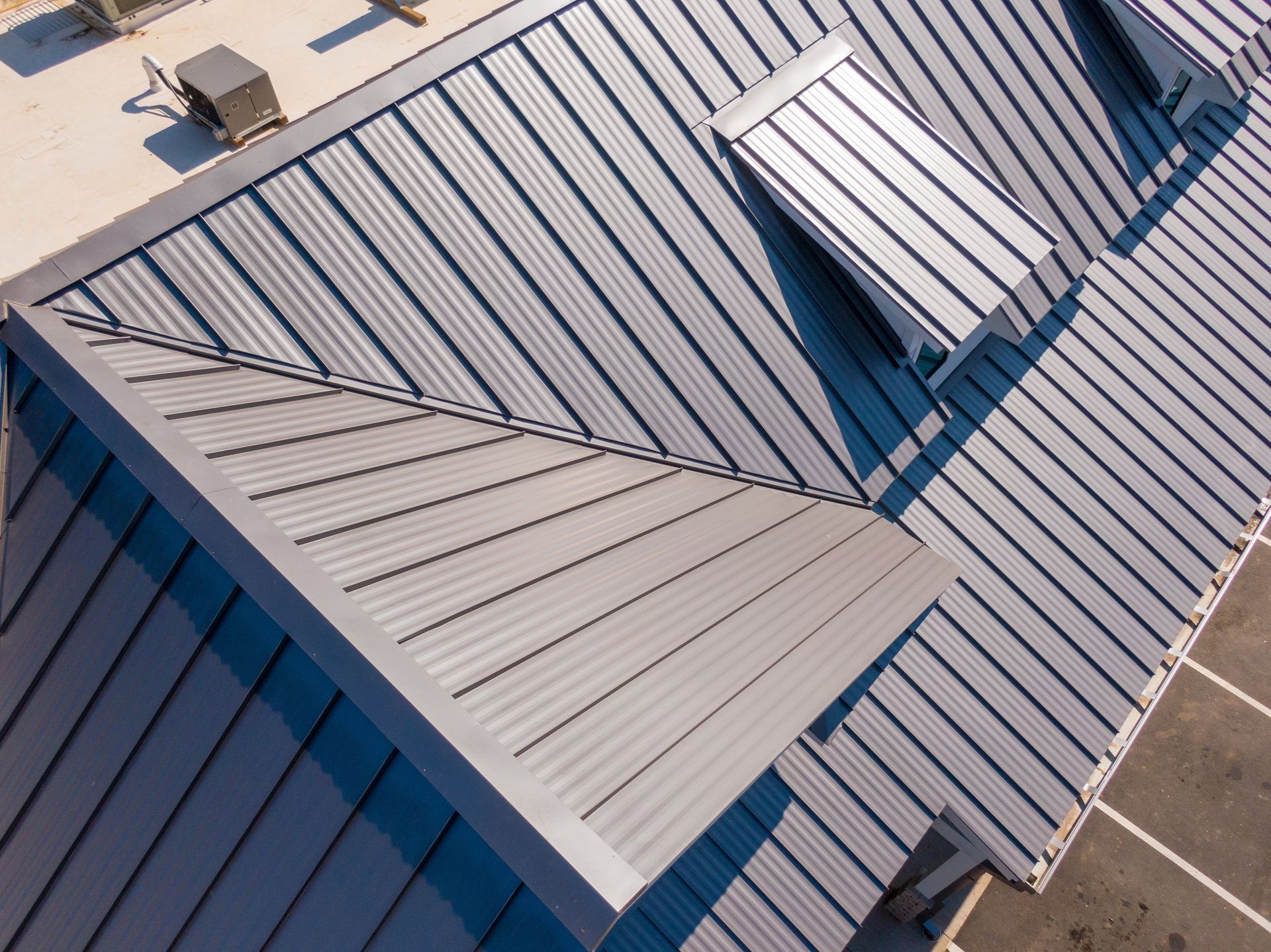 Blue metal roof with several rectangular skylights viewed from above