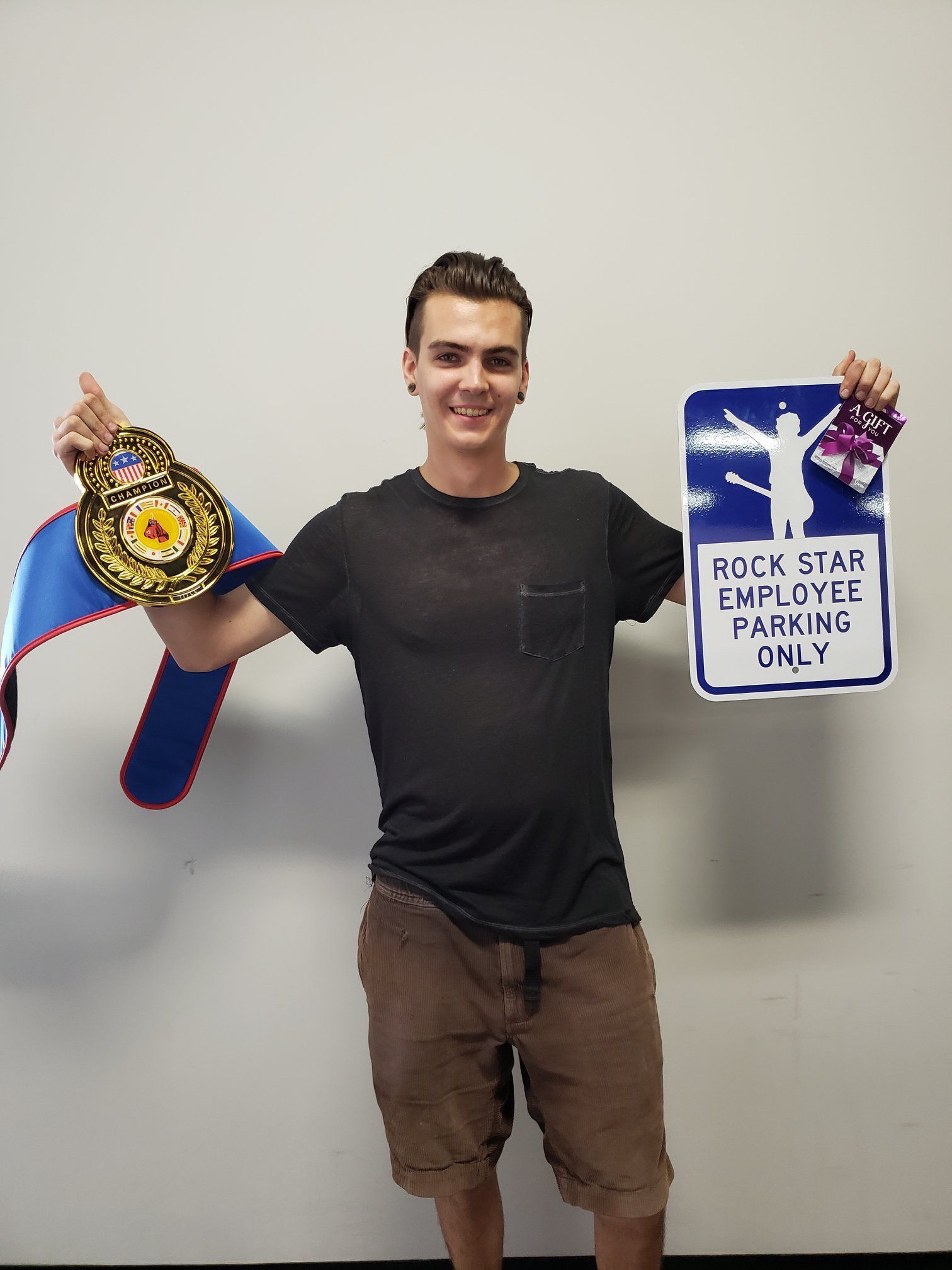 Young man holding a championship belt and a