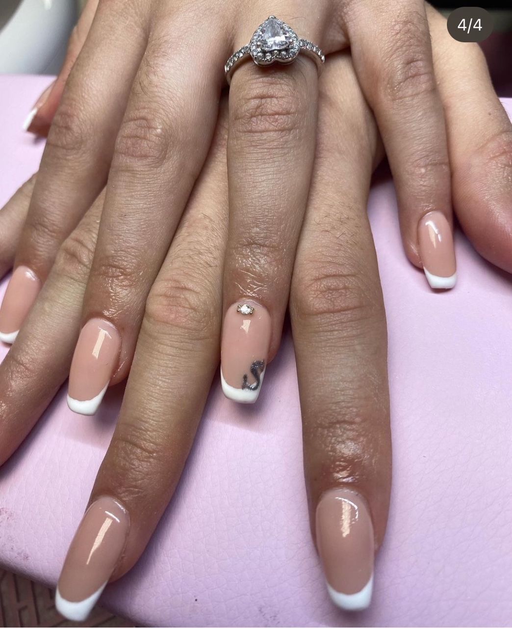 Een close-up van de nagels van een vrouw met een ring aan haar vinger