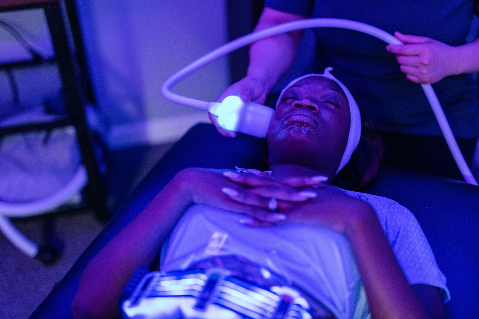 a woman is laying on a bed getting a facial treatment .