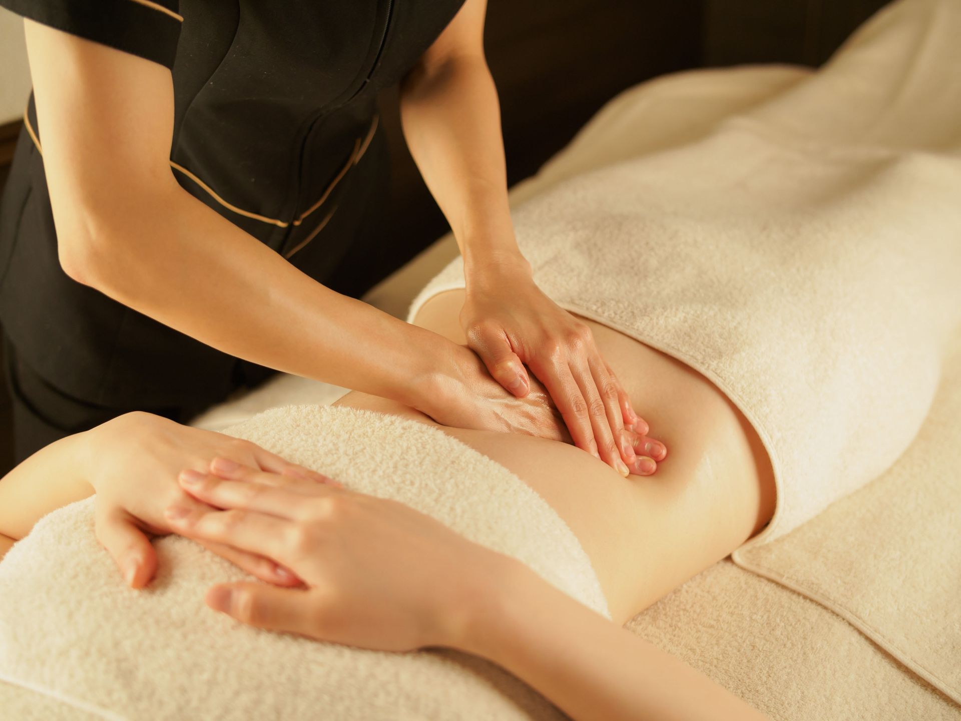 Asian female esthetician massaging her stomach