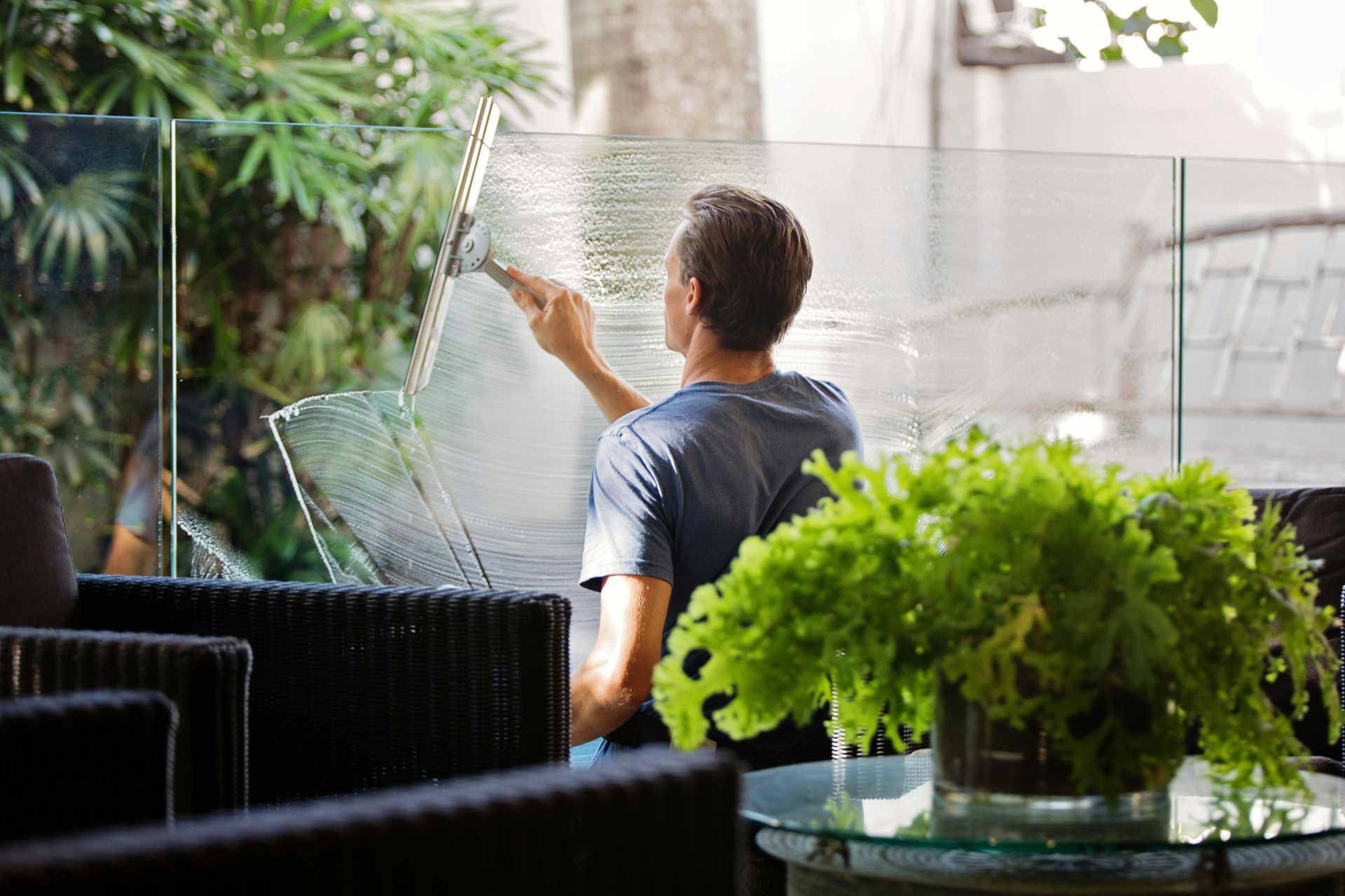 A man is cleaning a window with a squeegee.
