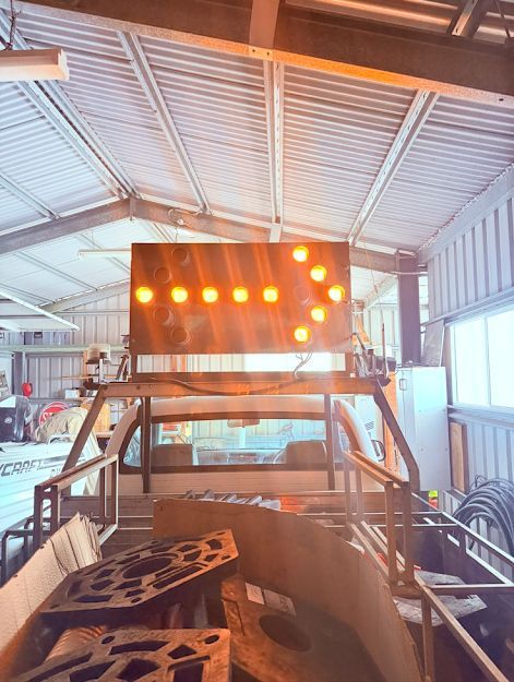 Orange warning lights mounted on a vehicle inside a metal-roofed workshop