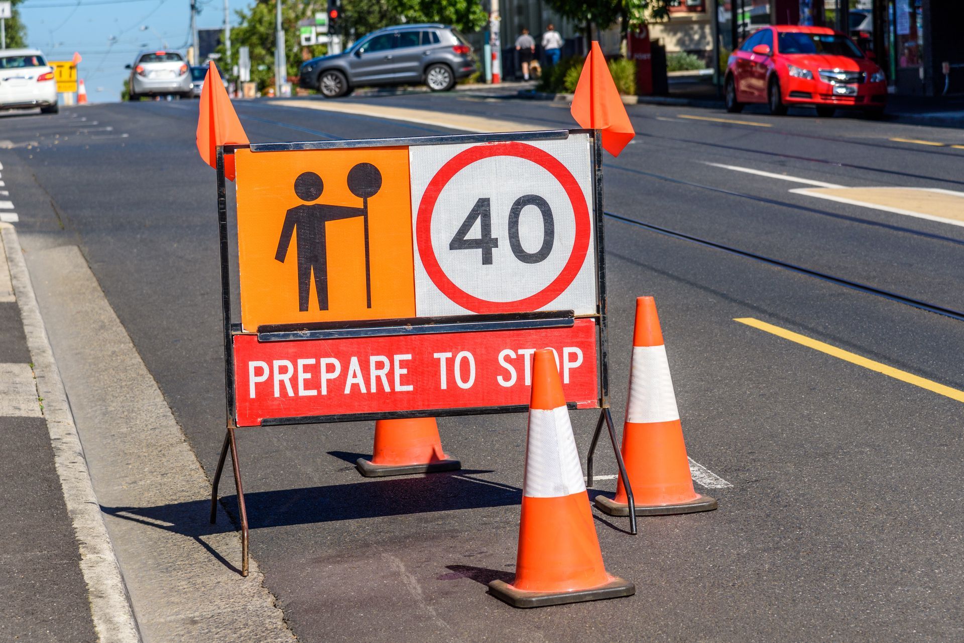 Roadwork sign with 40 speed limit and Prepare to stop signage surrounded by orange cones.