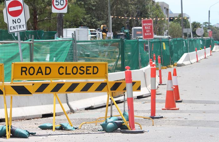 Road closed sign and orange traffic cones blocking a street construction area Road closed sign and orange traffic cones blocking a street construction area