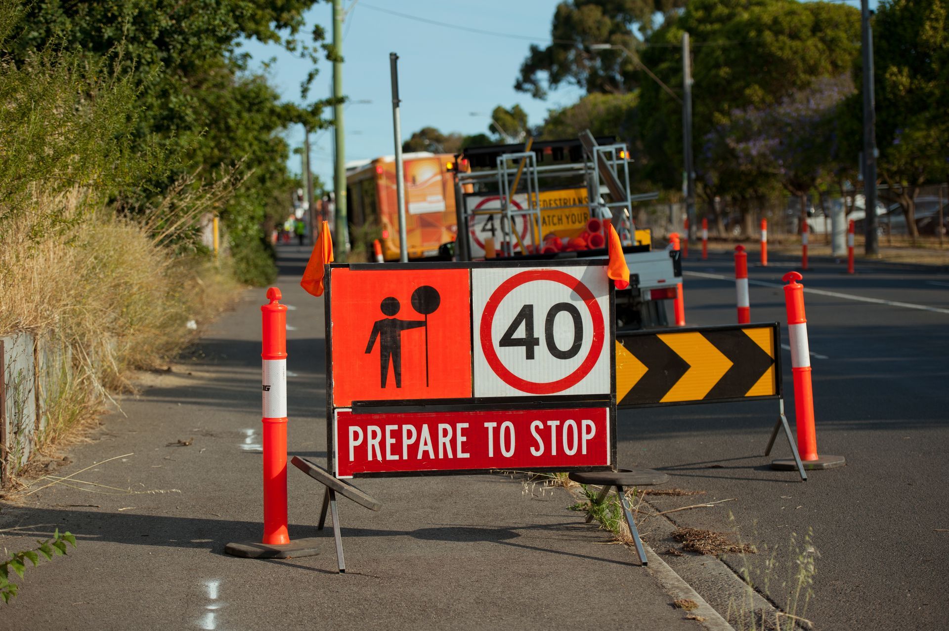Roadwork sign beside 40 km/h signs and traffic cones on a road under construction