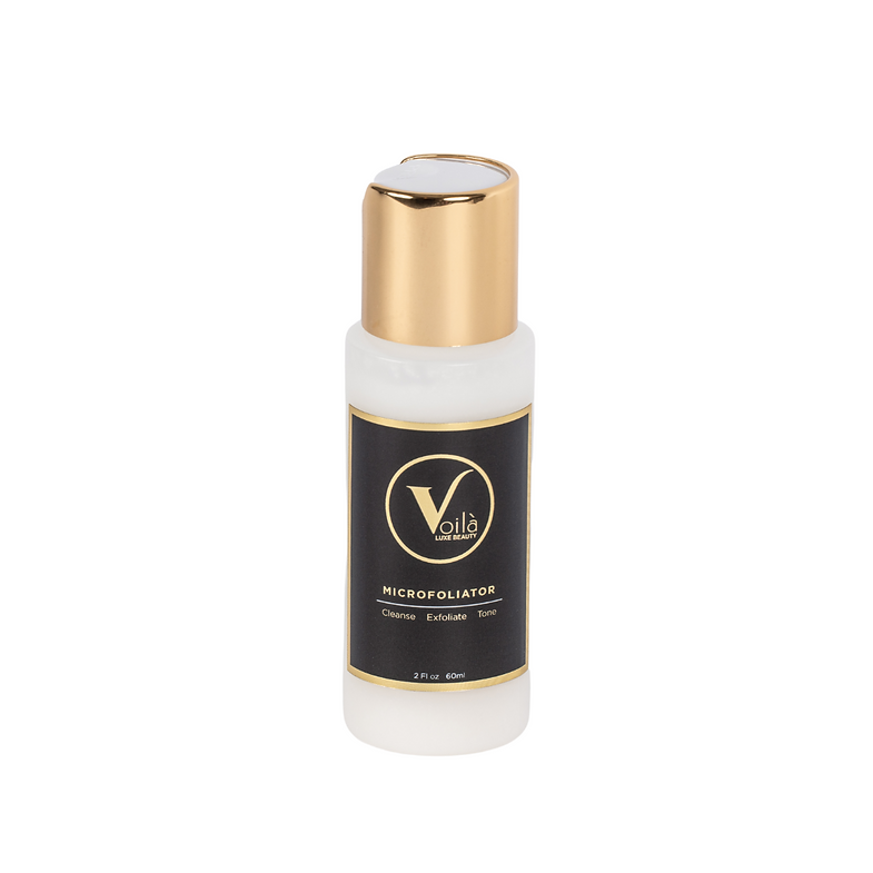 White cosmetic bottle with a gold cap and black label on a plain background