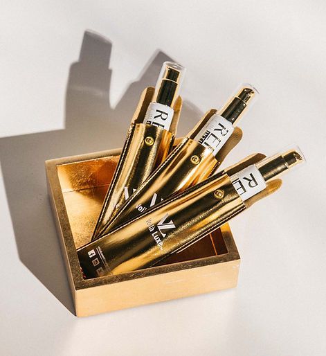 Gold rollerball pens in a matching box on a white background