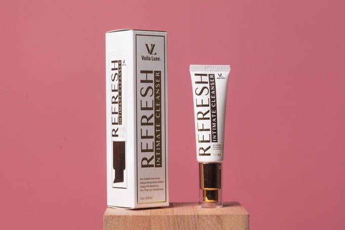 REFRESH skincare box and tube on a wooden block against a pink background