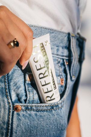 Hand holding a REFREC card at the pocket of blue denim jeans