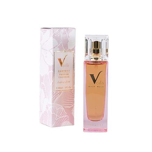 Pink perfume bottle with gold cap beside matching pink floral box.