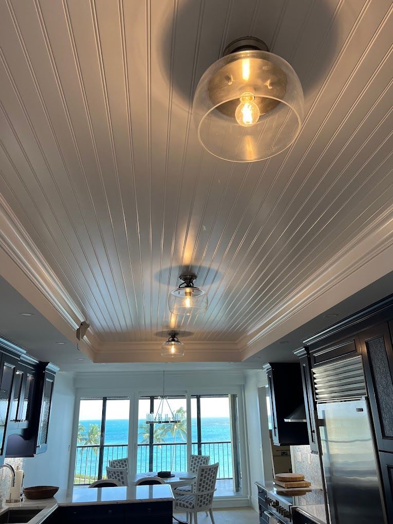A kitchen with a ceiling light hanging from it and a view of the ocean.