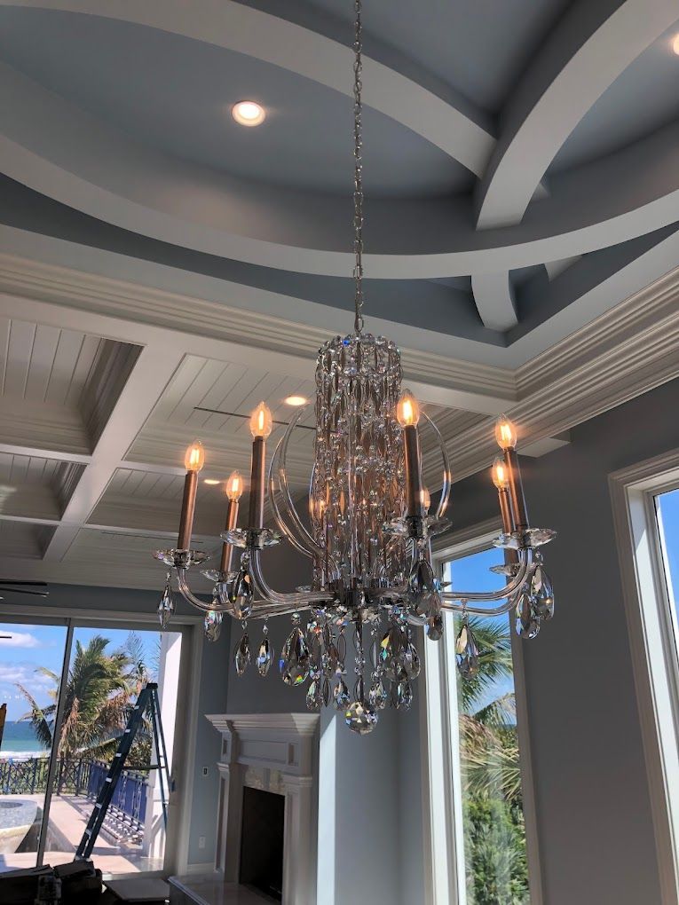A large chandelier is hanging from the ceiling of a living room.