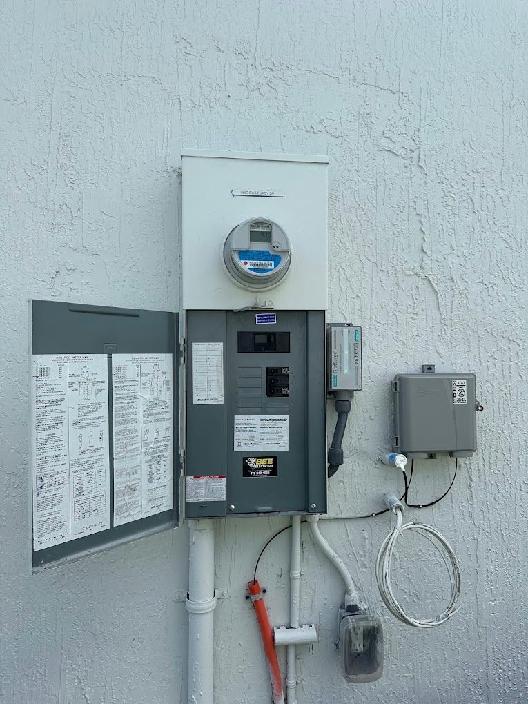 An electrical box is attached to a white wall.