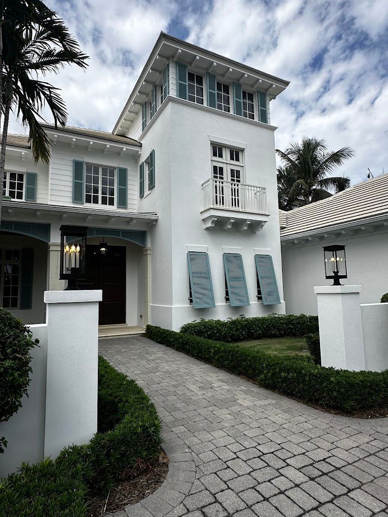 A large white house with blue shutters on the windows