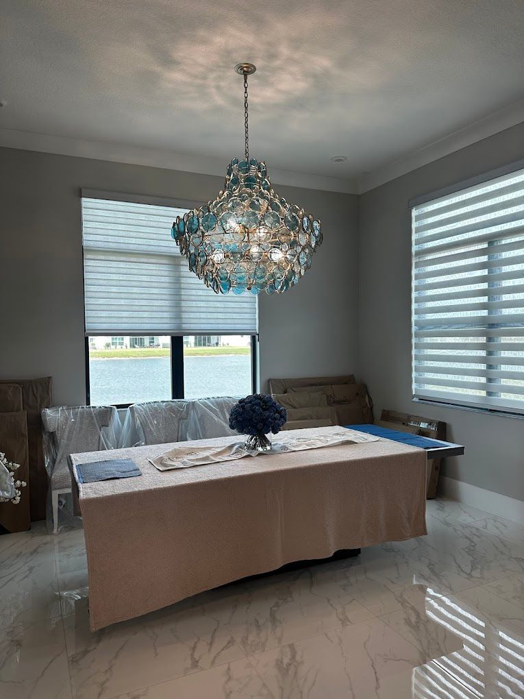 A dining room with a table and a chandelier hanging from the ceiling.