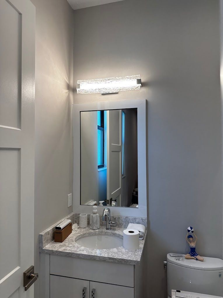 A bathroom with a sink a toilet and a mirror