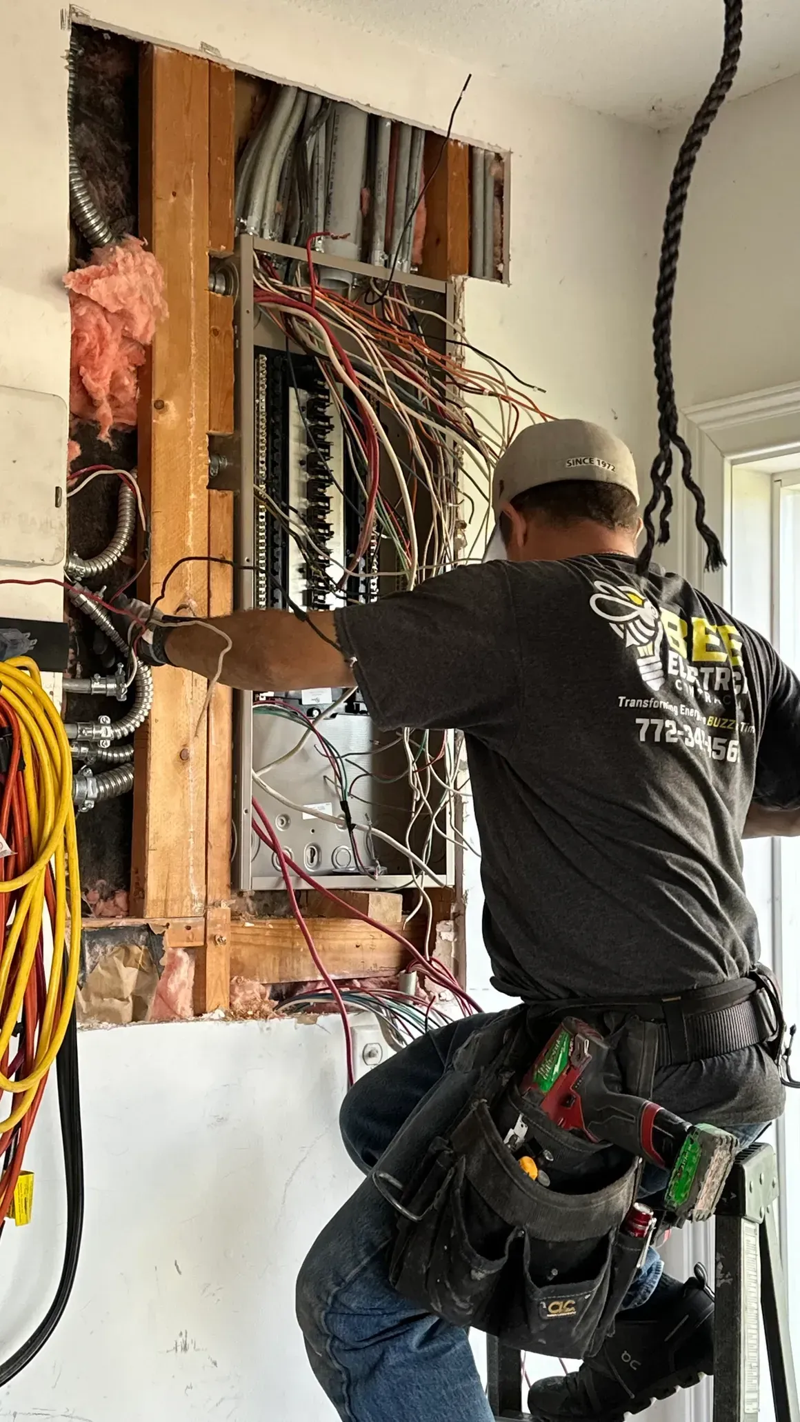 A man is working on an electrical box in a room.