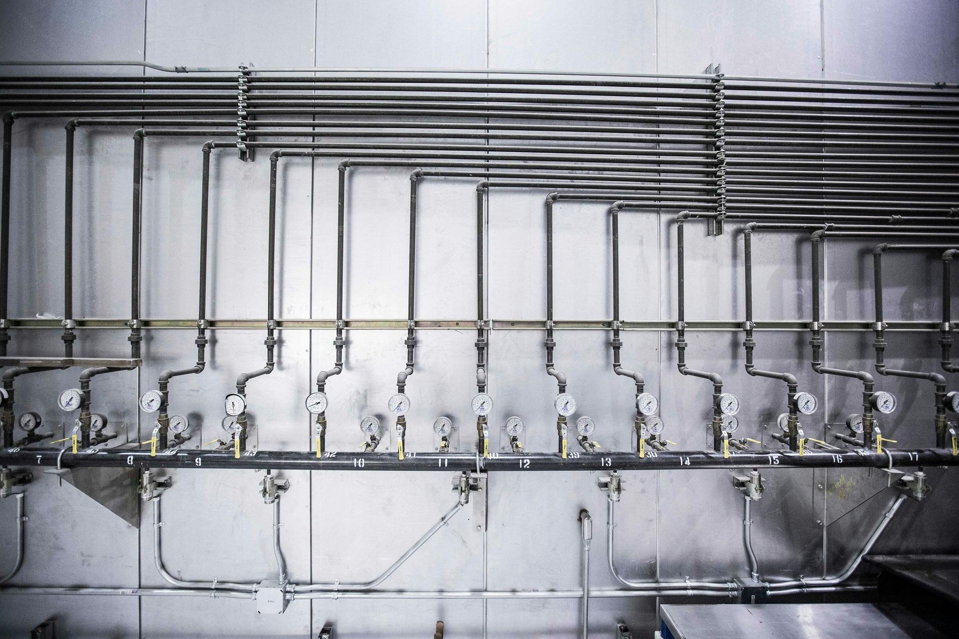Stainless steel pipes with gauges, mounted on a wall
