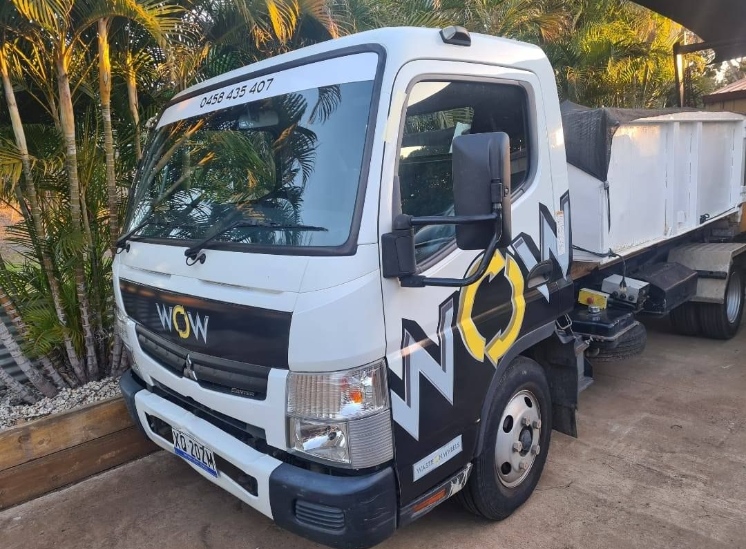 White dump truck parked on a driveway beside palm trees and greenery. — Bad Bugs Pest Control in Rockhampton, QLD