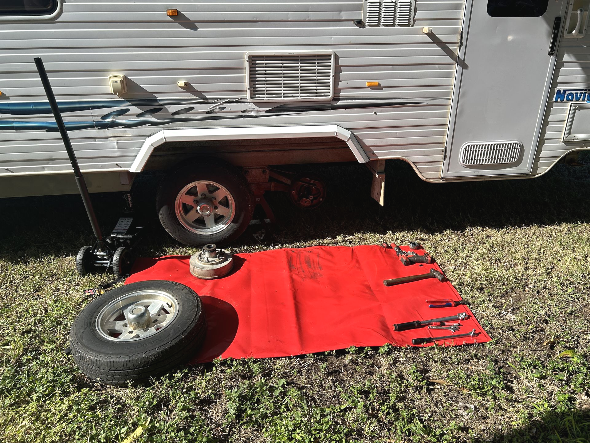 Red towel with tools and tire next to white caravan — I & J Mechanical in Deeragun, QLD
