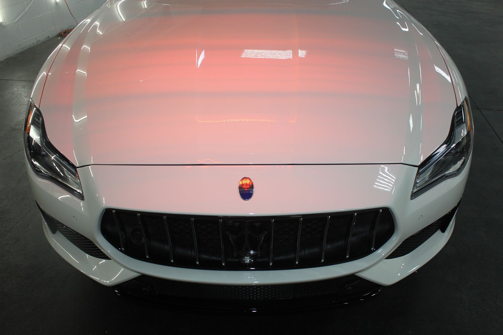 Front view of a white sports car with a black grille and headlights.