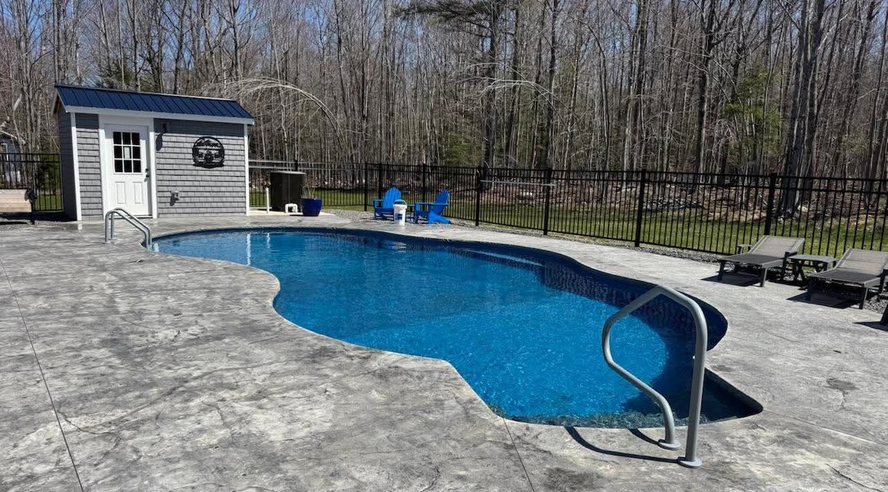 A large swimming pool is being built in a backyard.