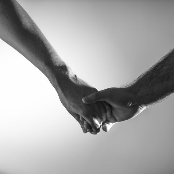 Two hands clasped together, black and white.