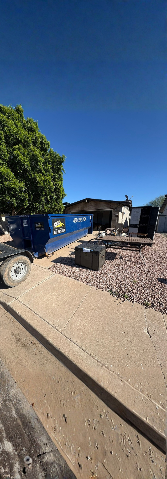 Blue 20 yard dumpster next to an estate clean out
