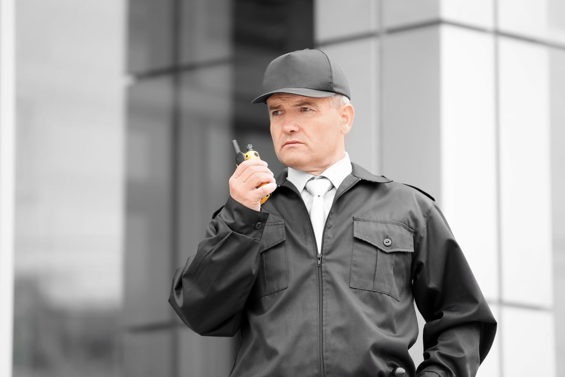 Male security guard holding a walkie talkie.