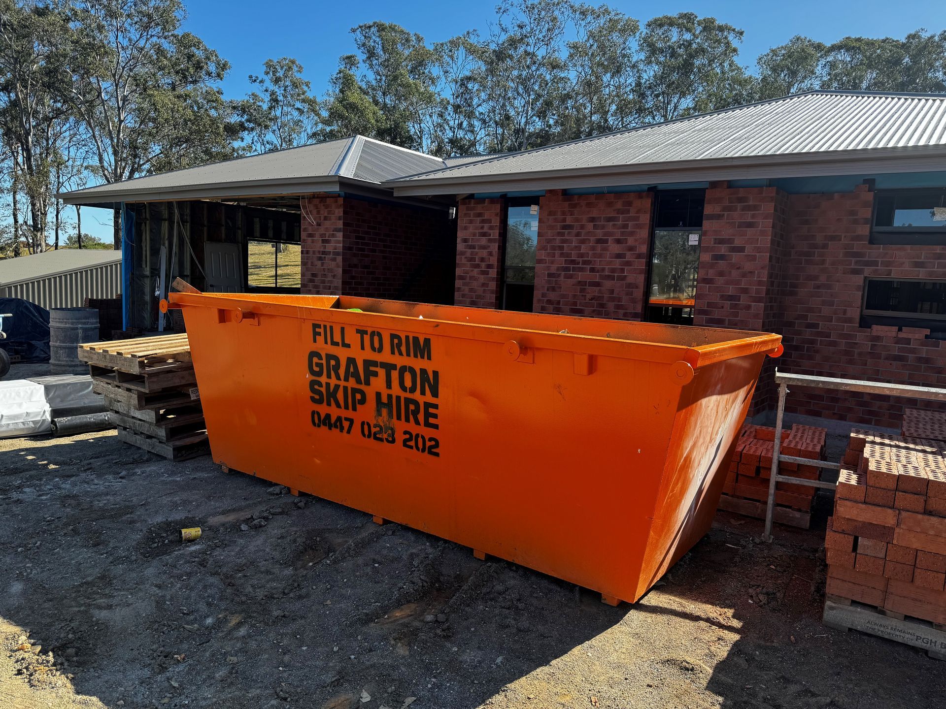 A Green Dumpster Filled With Cardboard Boxes and Other Trash — Grafton Skip Hire–Zims Bins in South Grafton, NSW