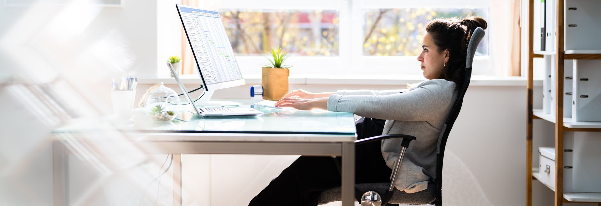 Woman slumped in her office chair, she is researching an office ergonomics checklist