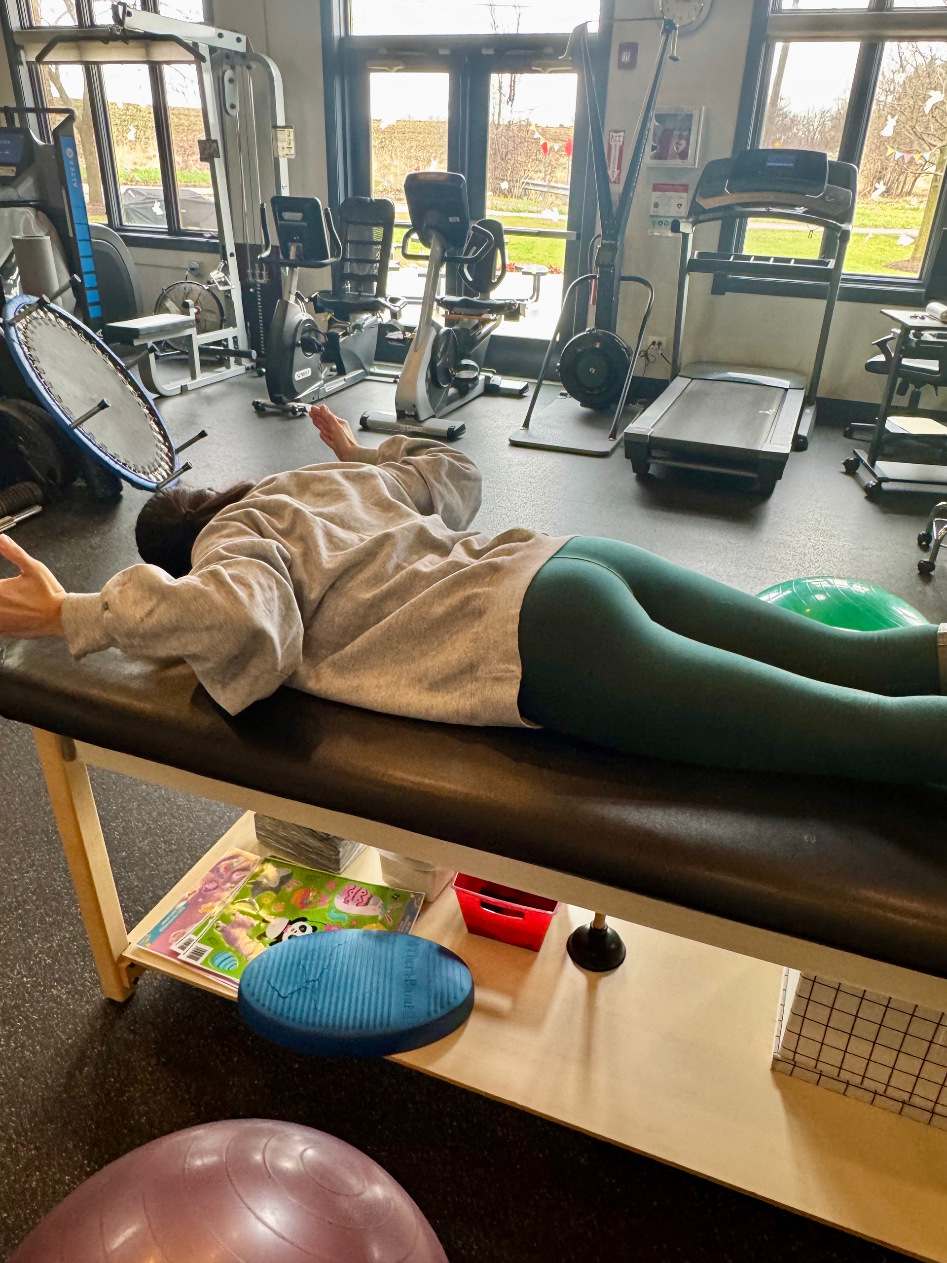 A person is laying on a table in a gym.