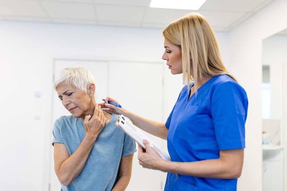 woman speaking with a physical therapist about the whiplash she has been experiencing