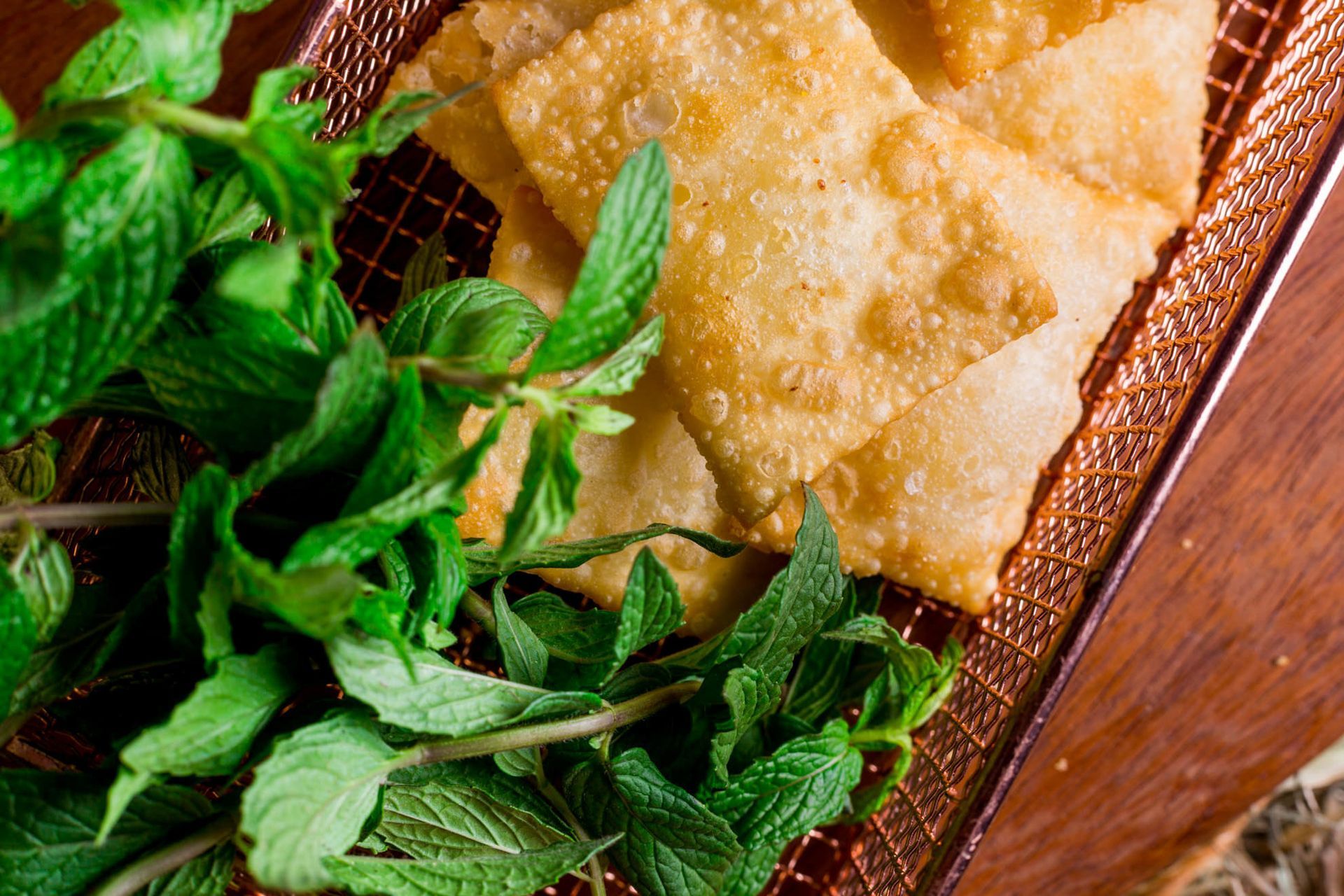 Cesta de pastel frito com folhas frescas de hortelã