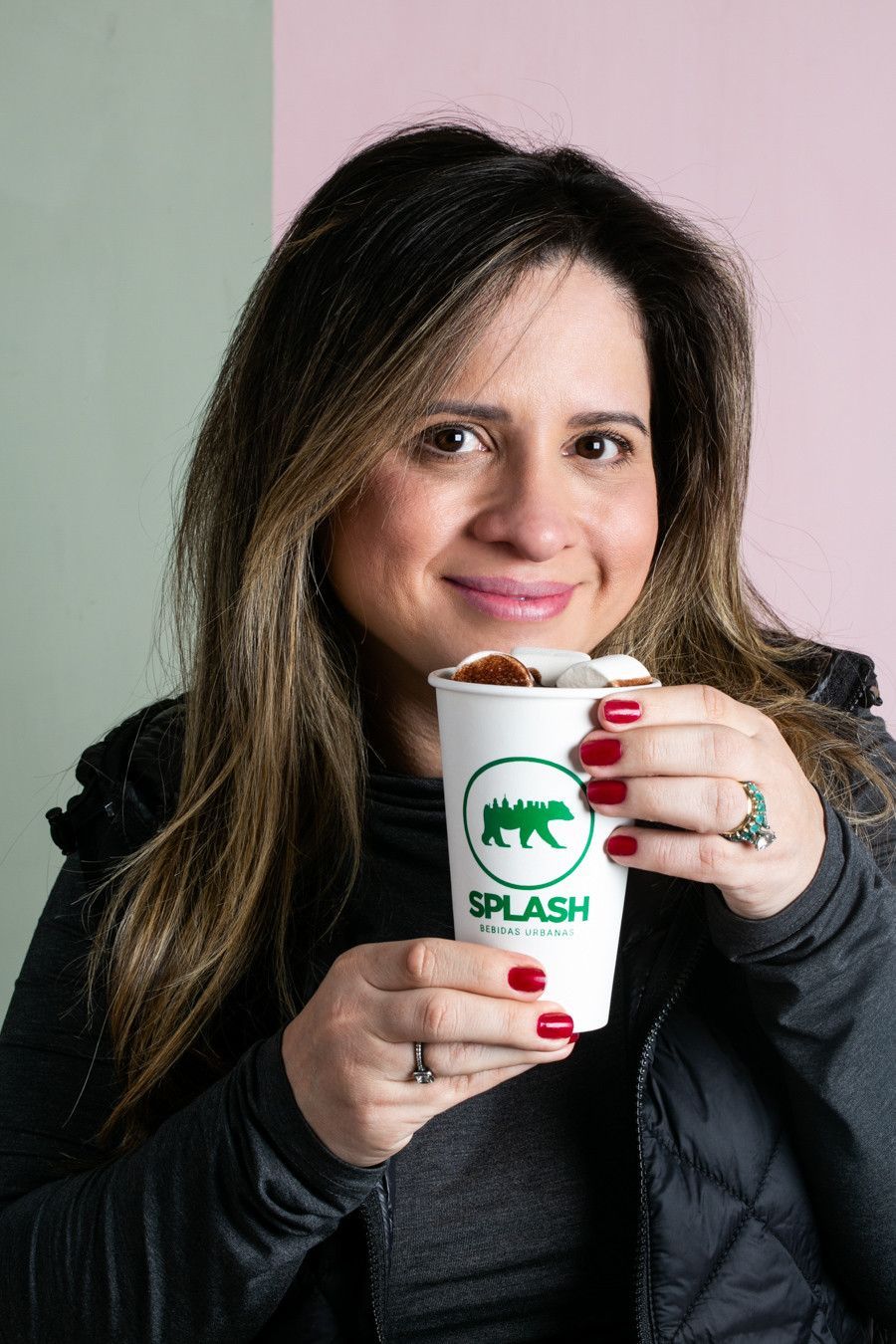 Mulher segurando uma xícara de café branca com o logotipo verde