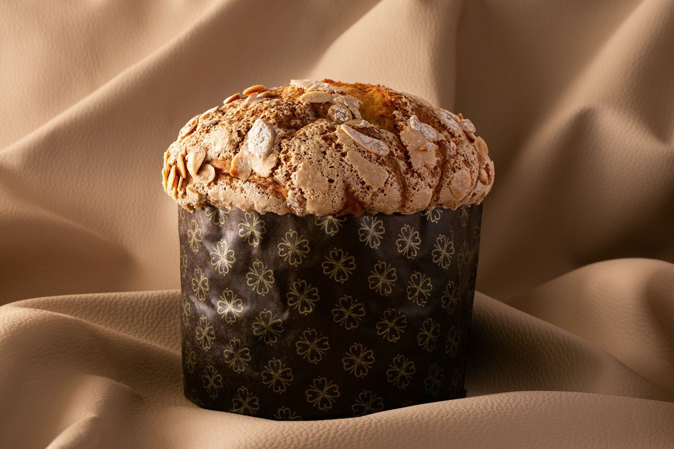 Bolo de chocolate com cobertura leve de glacê sobre fundo de tecido bege drapeado